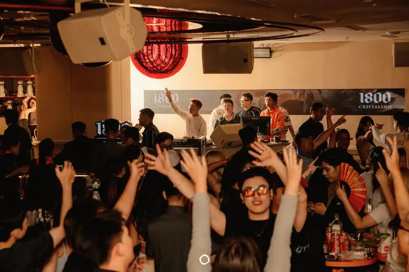 Khách nâng tay theo nhạc trước bàn DJ tại NOA